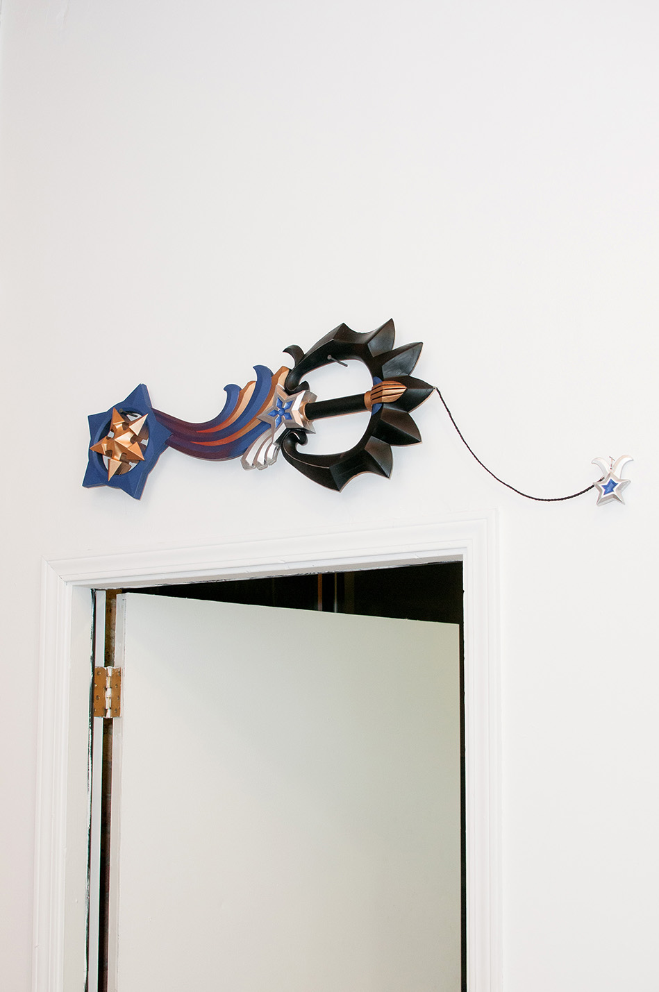 A prop stylized sword mounted on a wall above a door frame